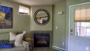 Built-in, propane  fireplace with a stone surround and a visible  close by white switch to  on the warm heat.... once you have the piolet light going.