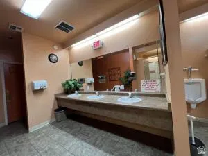 Men's dressing room with vanitys, showers and stalls.