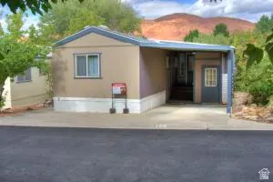 Single-story residence with a covered carport, elevated entry, and durable siding. The driveway will park two cars. One in the covered port and one parallel in front of the home.