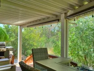 Covered patio featuring a solid roof, integrated lighting, and outdoor shades