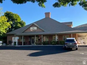 Pitched roof building with a prominent brick chimney, multiple windows, and an asphalt parking area.  Tour of the club house follows.....