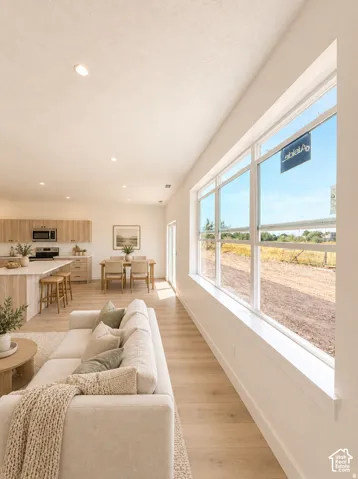 Recessed ceiling lighting, wood-finish flooring, large multi-pane window, kitchen island with seating, built-in cabinetry