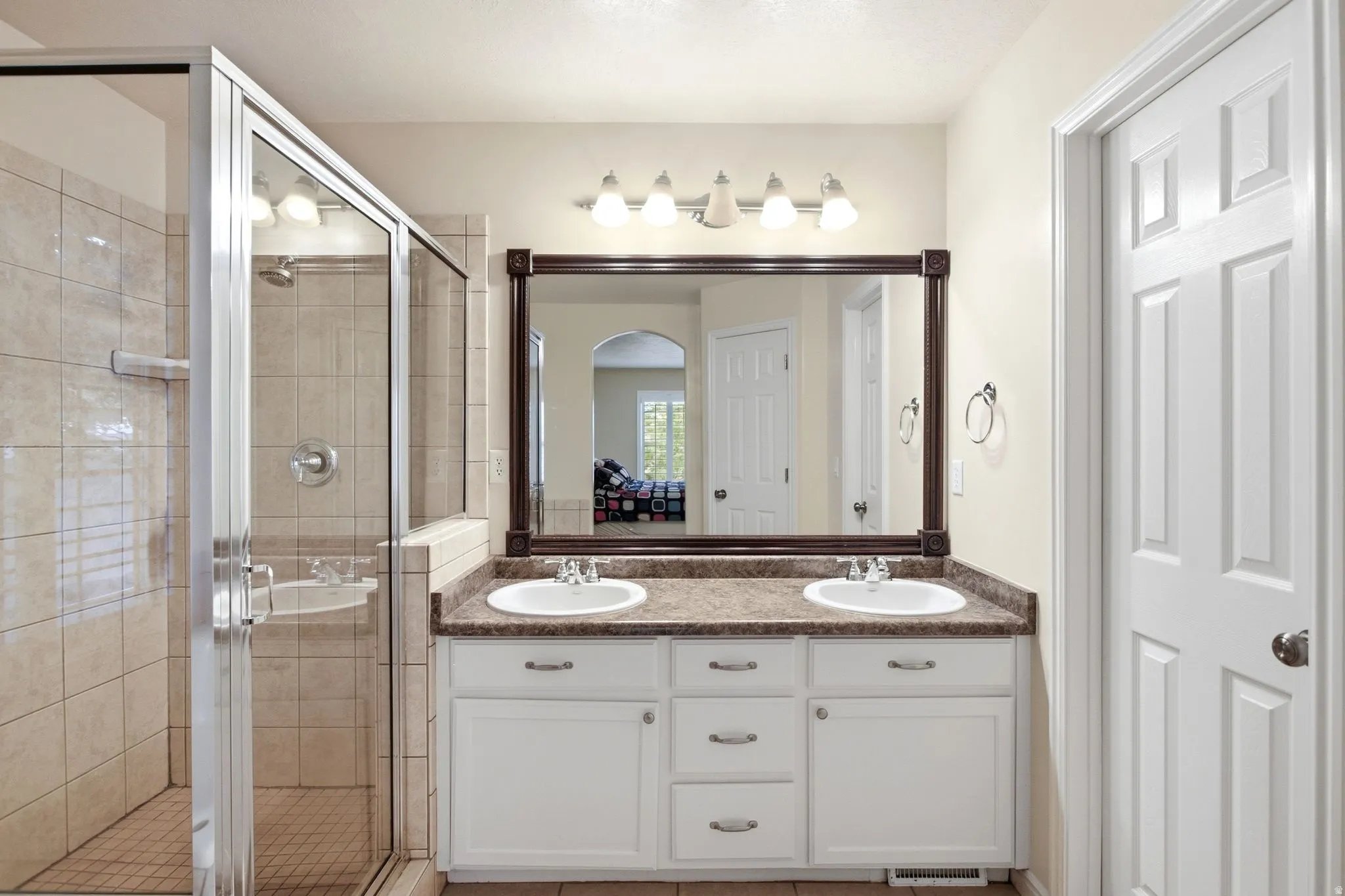 Dual vanity with integrated sinks, framed mirror, and white cabinetry