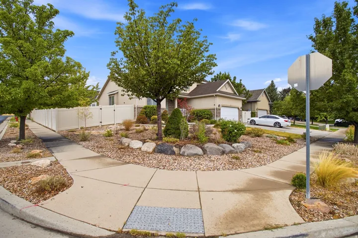Stucco exterior with stone accents, attached garage, and a fenced perimeter