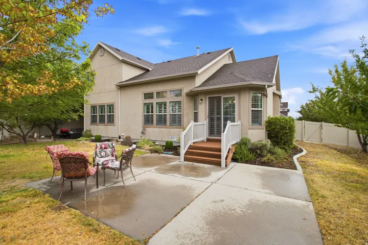 Expansive concrete patio with a wood-finish deck and white railings