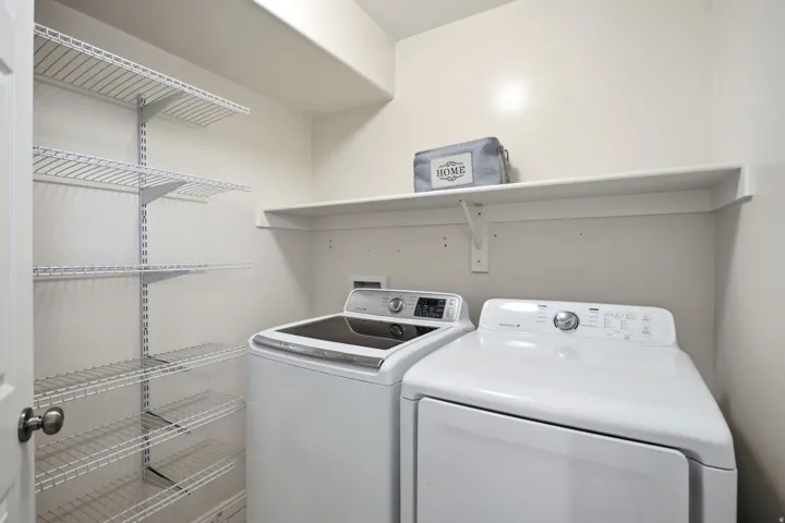 Laundry area with wall-mounted wire shelving and an upper storage shelf