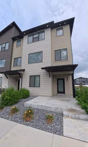 Contemporary exterior with a mixed material facade, clean-lined windows, black trim accents, a concrete walkway, and low-maintenance landscaping