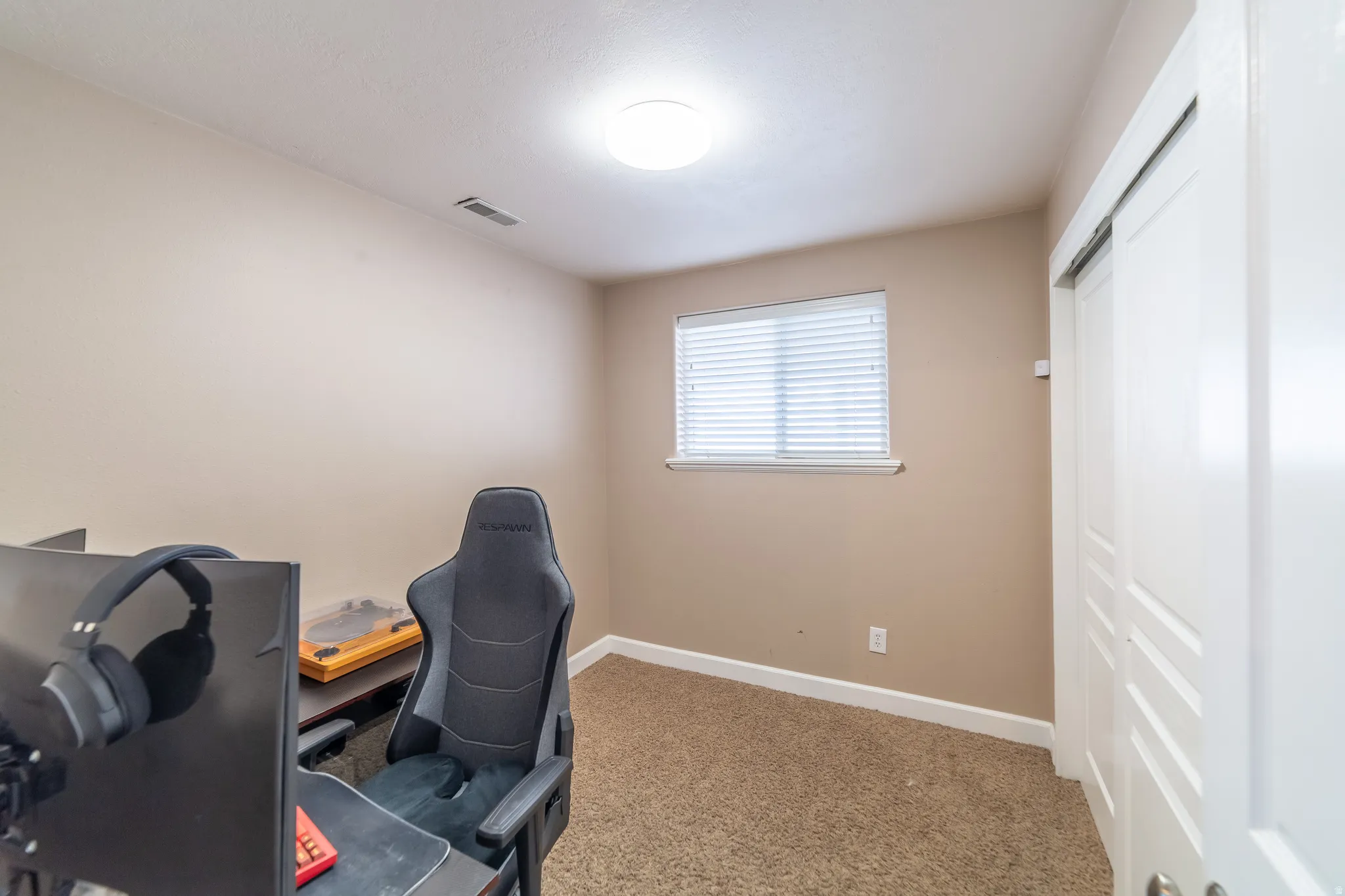 Neutral-toned walls, a window with blinds, recessed ceiling light, and wall-to-wall carpeting