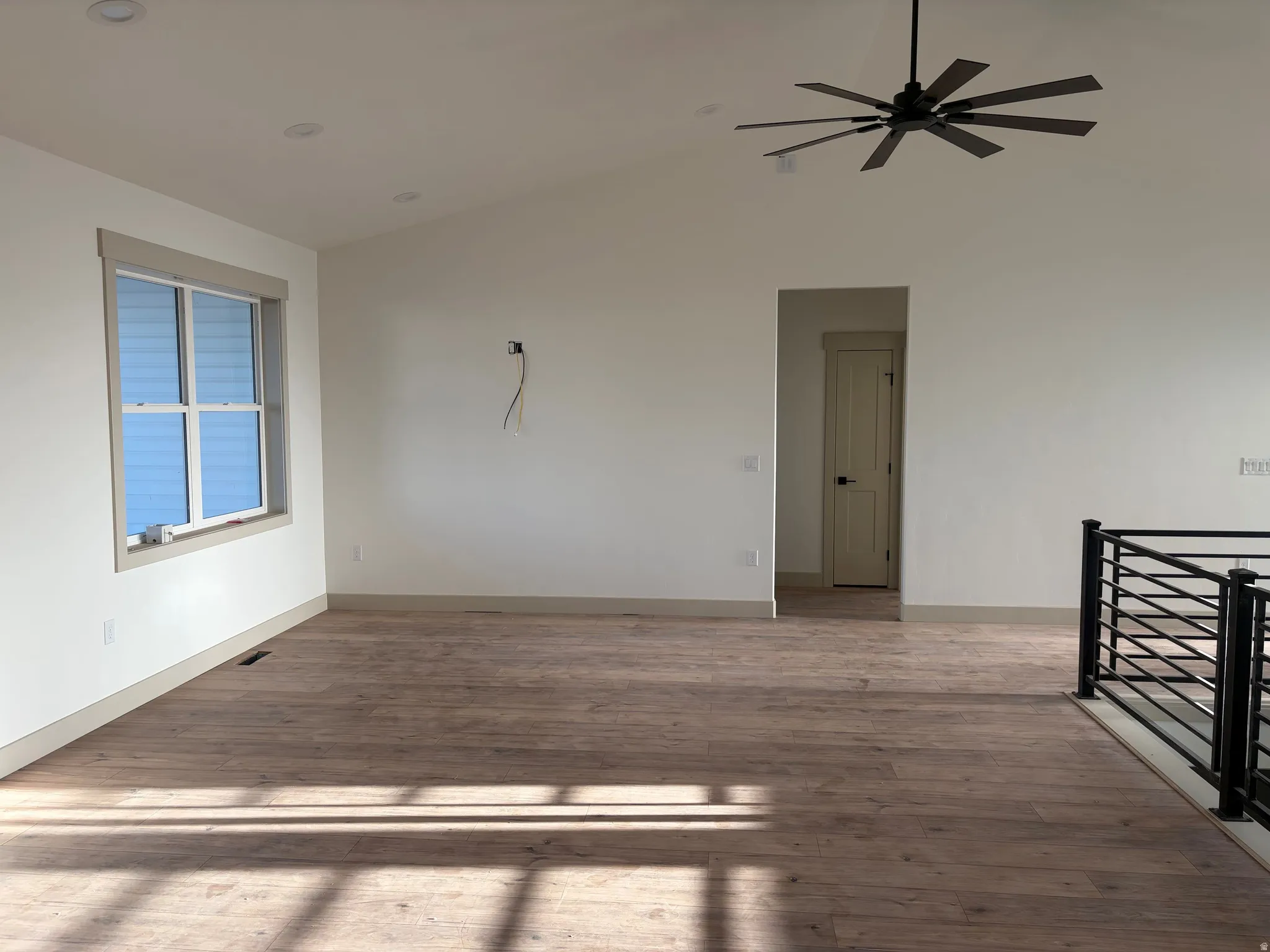 Vaulted ceiling with recessed lighting and a ceiling fan