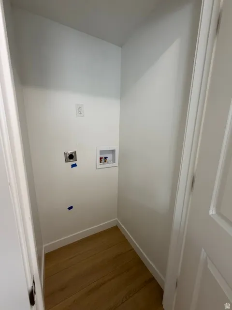 Utility area with light wood-finish flooring and white walls