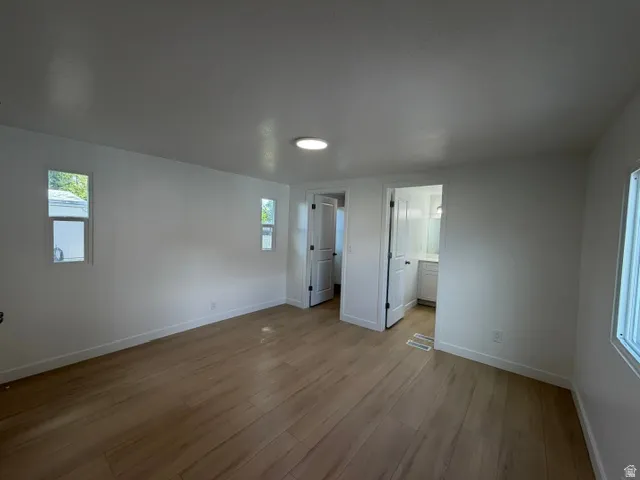 Wood-finish flooring, recessed lighting, and white interior walls