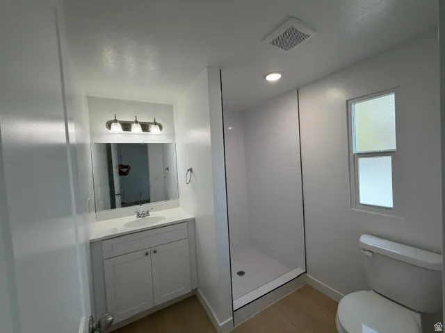 Contemporary bathroom with a white vanity, integrated sink, and quartz countertop