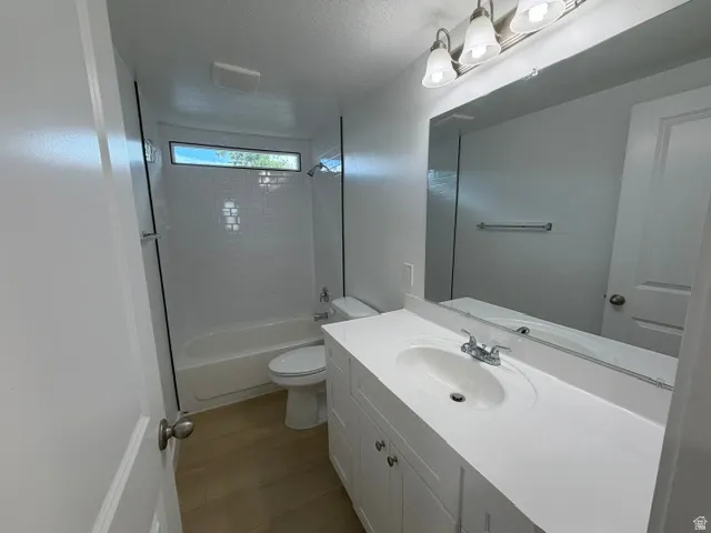 White vanity with integrated sink, chrome faucet, and expansive mirror