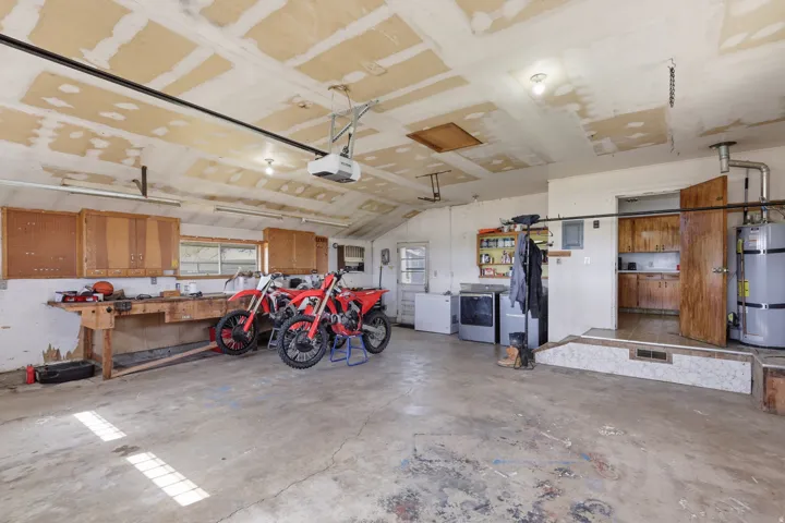 Spacious garage with concrete flooring, built-in workbench, and overhead lighting