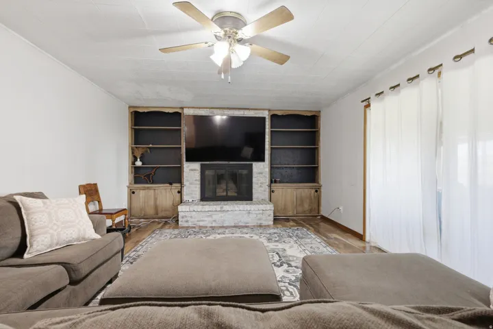 White brick fireplace with an integrated media niche, flanked by built-in shelving and lower cabinetry