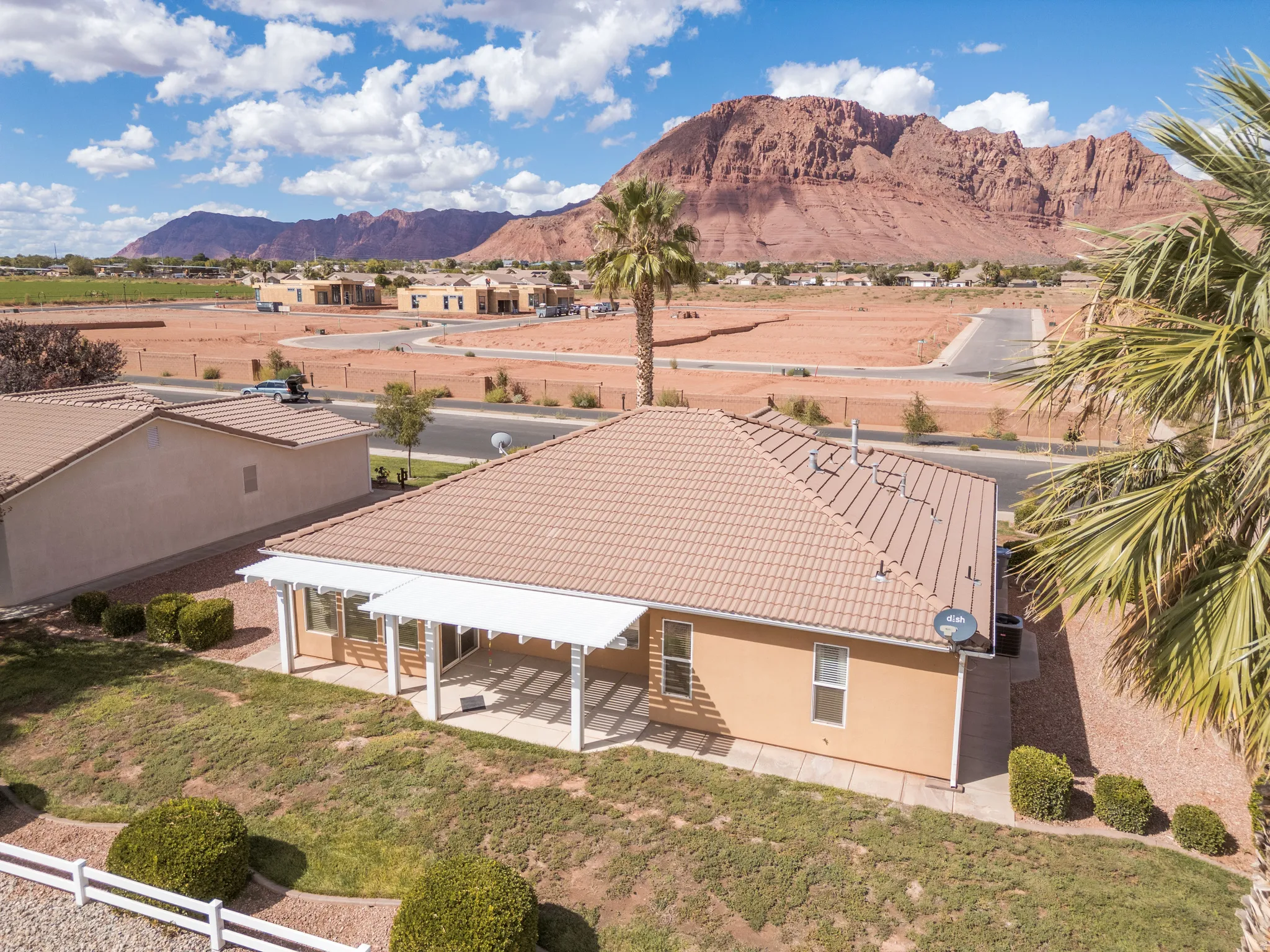Terracotta-tiled roof, covered patio, desert landscaping, and distant mountain range