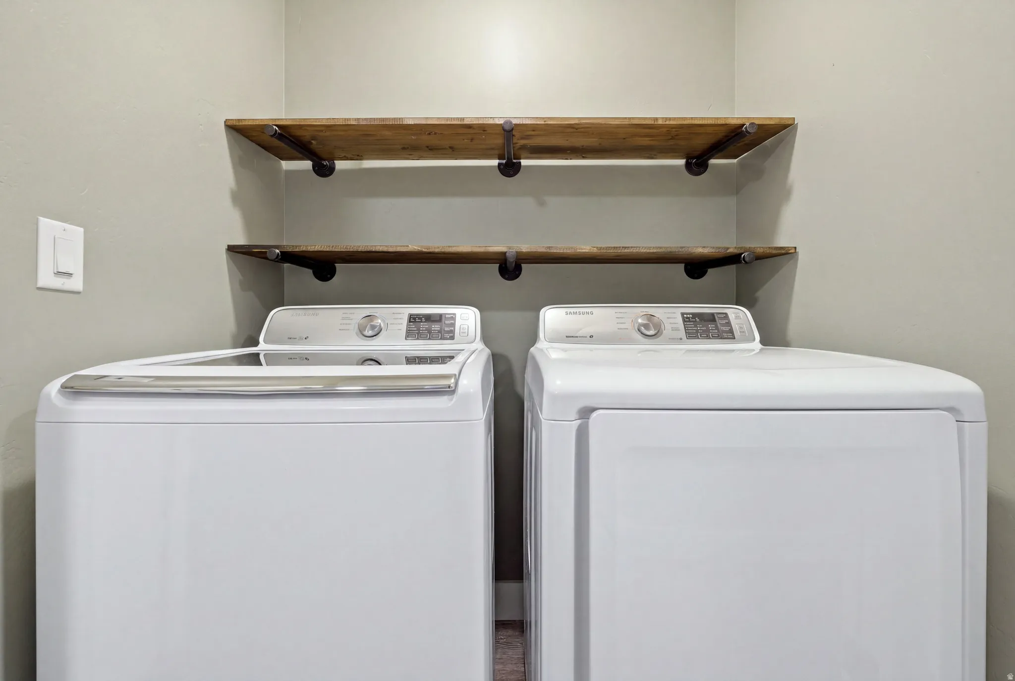 Two wood-finish floating shelves with dark metal supports