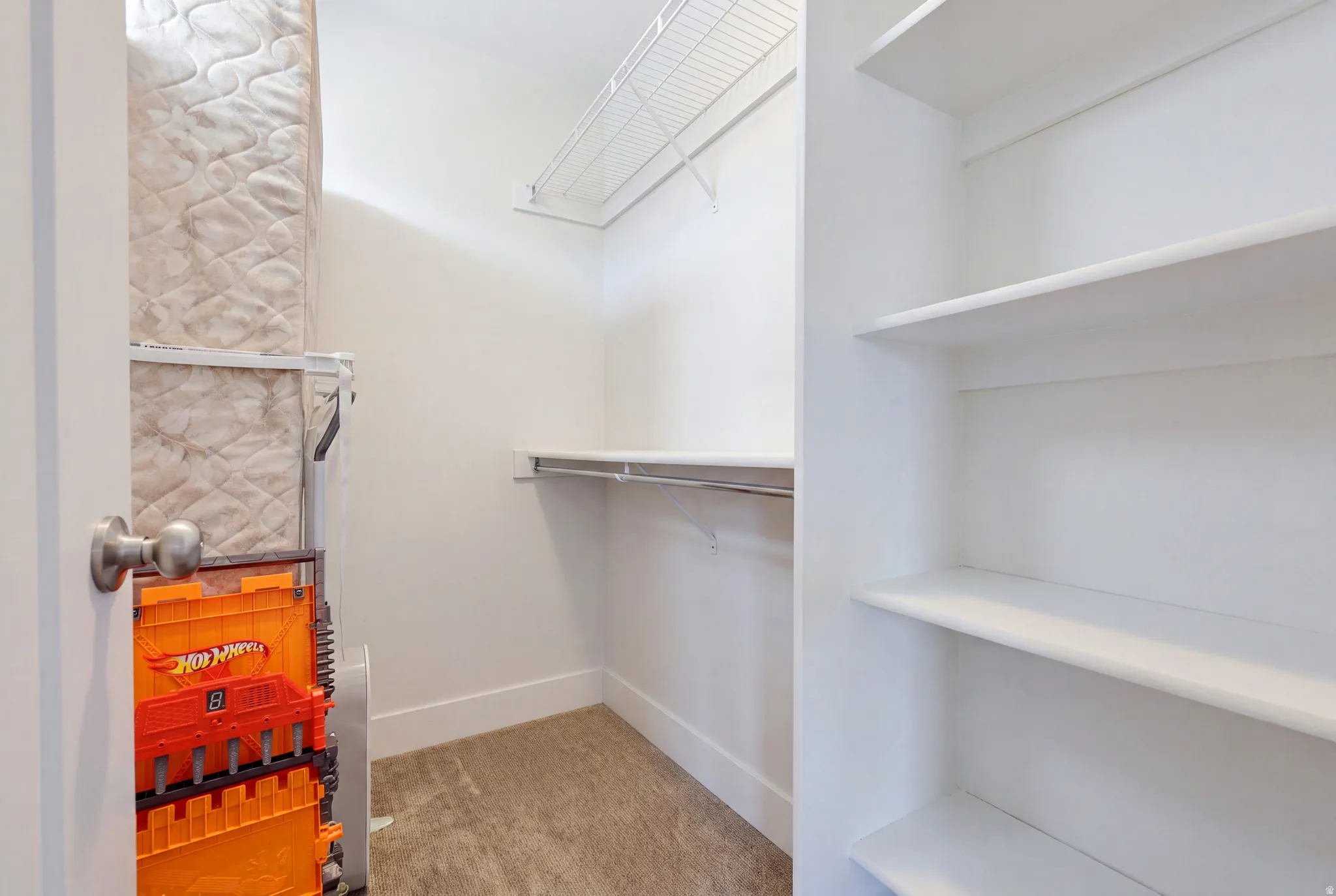 Built-in shelving and a clothing rod offer storage solutions within this space