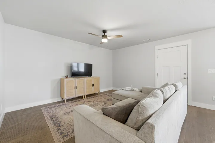 Recessed lighting, wood-finish flooring, ceiling fan, white paneled door, and white trim