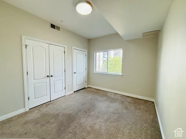 Recessed window, two paneled closet doors, single paneled door, and ceiling-mounted light fixture