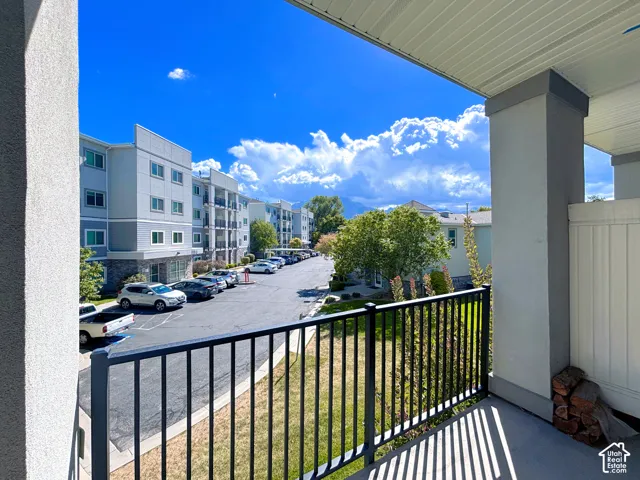 Balcony with black metal railing, concrete flooring, and surrounding mountain scenery