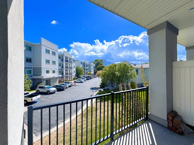 Balcony with black metal railing, concrete flooring, and surrounding mountain scenery