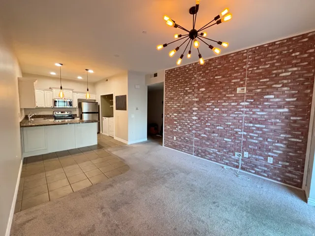 Kitchen featuring white cabinetry, stainless steel appliances, and a breakfast bar with pendant lighting