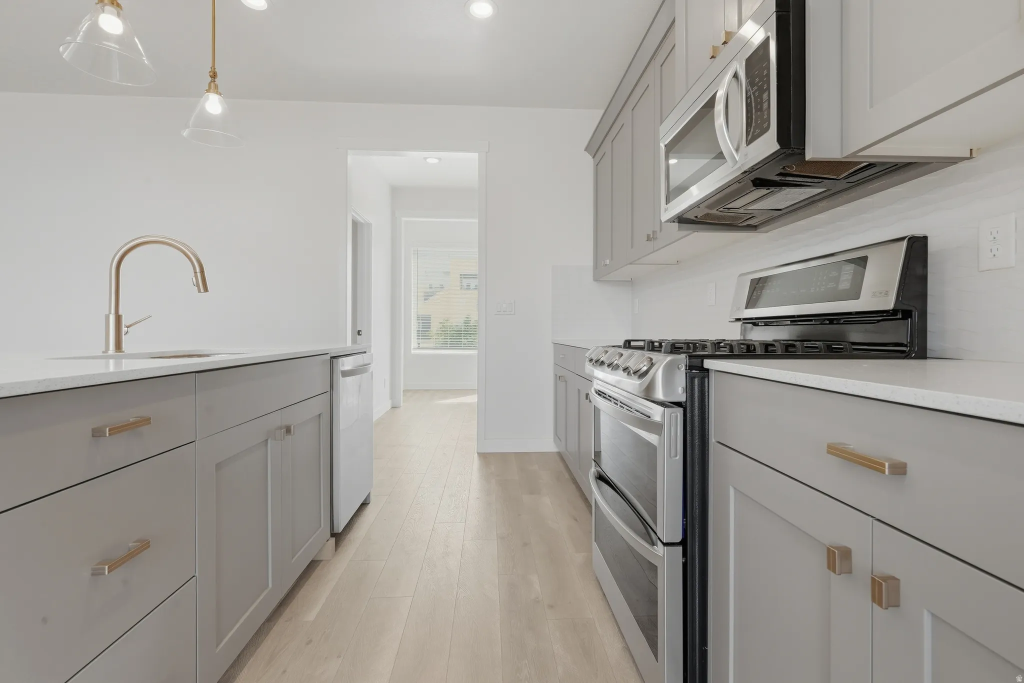 Light wood-finish flooring with white walls and recessed lighting