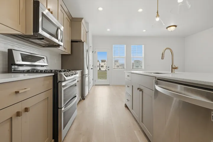 Kitchen featuring stainless steel appliances, wood-finish flooring, recessed lighting, and an island with an undermount sink and a gooseneck faucet
