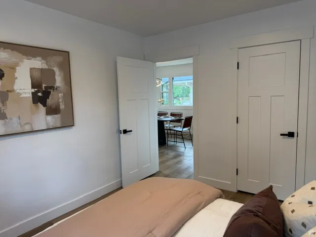 White interior doors with black hardware, wood-finish flooring, and white trim
