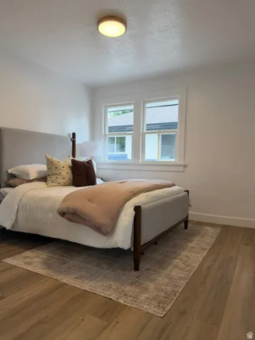 Wood-finish flooring, white walls, and a contemporary flush-mount ceiling light fixture
