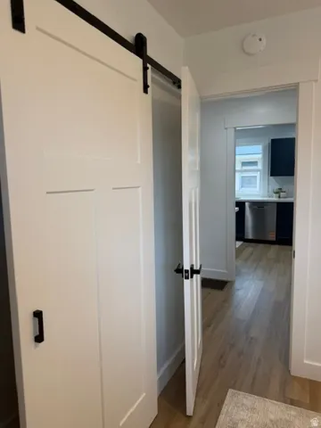 White panel doors with matte black hardware, wood-finish flooring, and crisp white trim