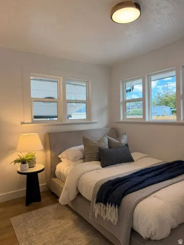 Wood-finish flooring, multiple windows, and a flush-mount ceiling light fixture