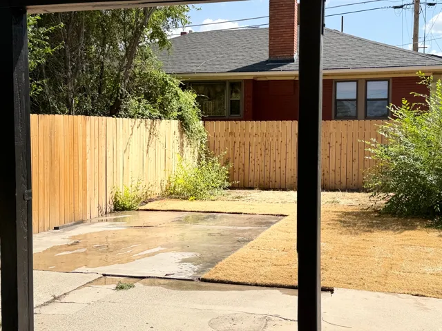 Private backyard with wood plank fencing, concrete patio, and new sod installation