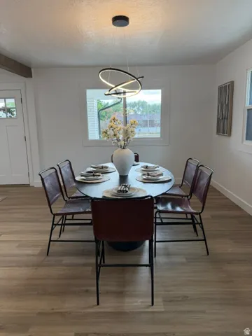 Wood-finish flooring throughout, white trim, and a contemporary chandelier