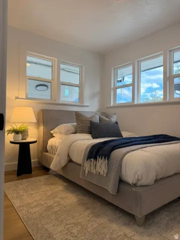 Wood-finish flooring, white walls, and multiple windows with white trim
