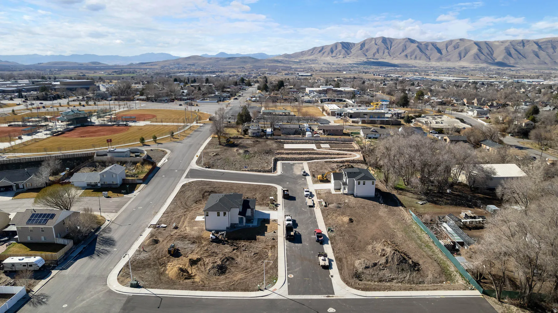 Newly constructed residential properties with paved street access and mountain backdrop