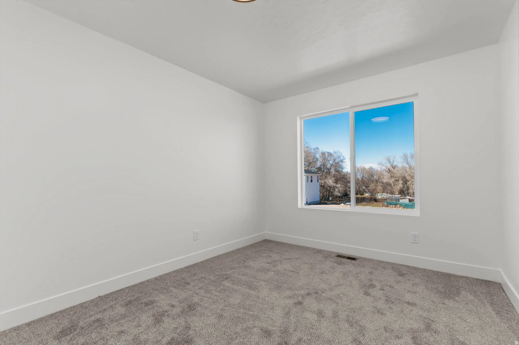Neutral wall paint, recessed ceiling light, carpet flooring, base molding, white window frame