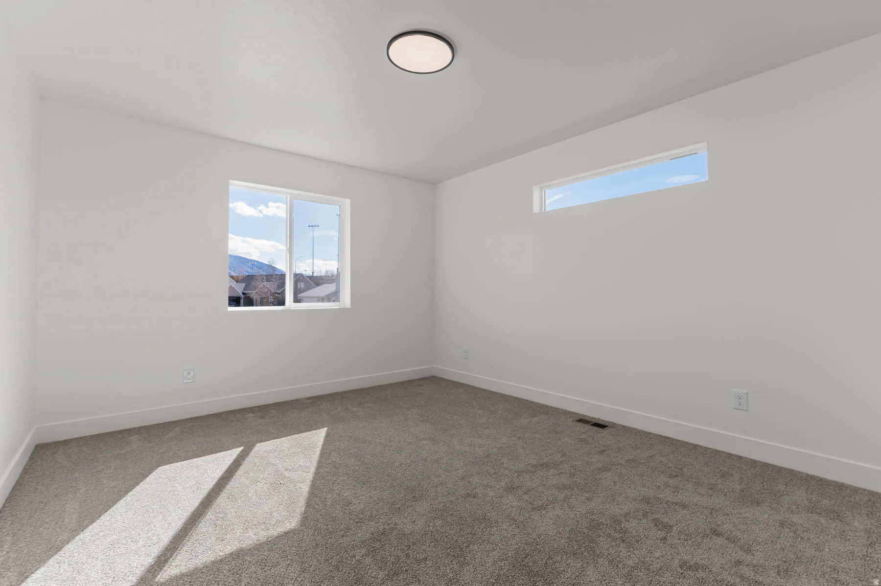 White painted walls, gray carpet flooring, white trim, recessed lighting, and dual windows