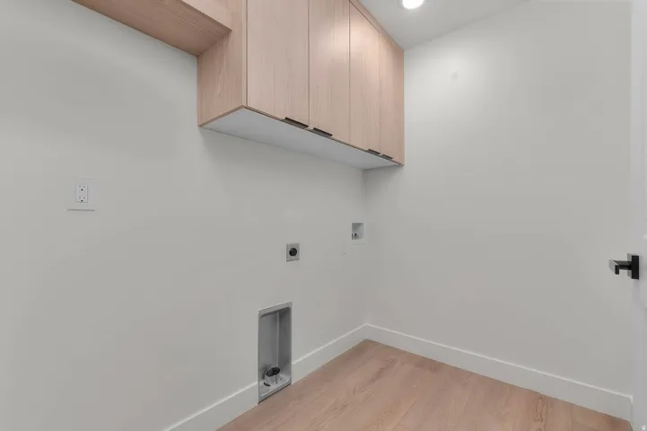 Wood-finish flooring, overhead cabinetry, and recessed lighting