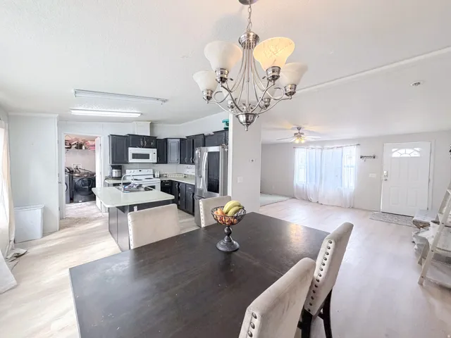 Open-concept living area featuring a kitchen with dark cabinetry, an island, and stainless steel appliances