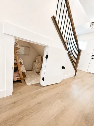 Wood-finish flooring throughout, featuring a staircase with wood handrails and black metal balusters