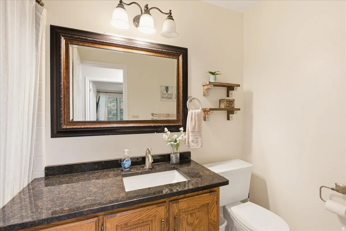 Built-in wooden vanity with a dark countertop and undermount sink