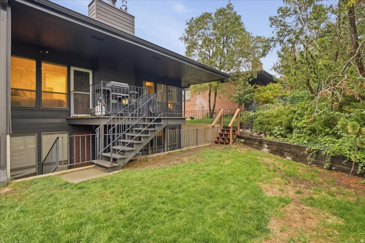 Exterior featuring a dark-toned facade, a raised deck with metal railings, and an exterior metal staircase