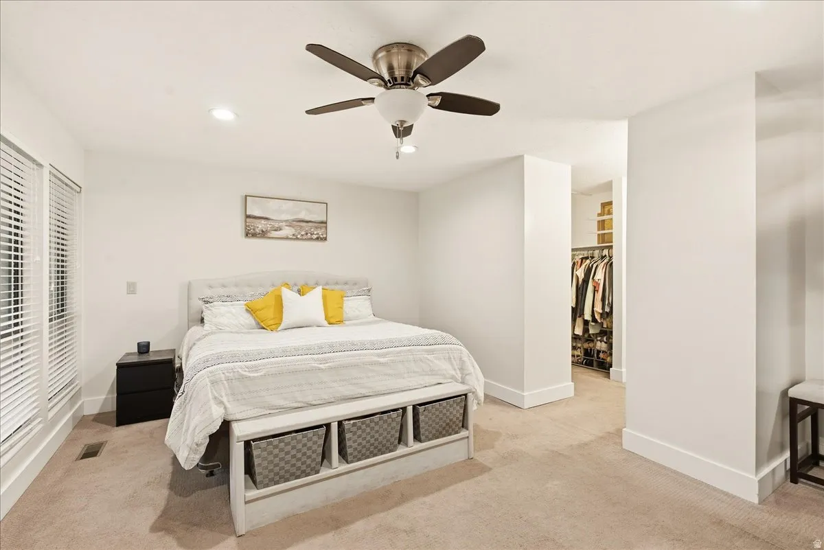 Recessed lighting, ceiling fan, white window blinds, and built-in closet organization system