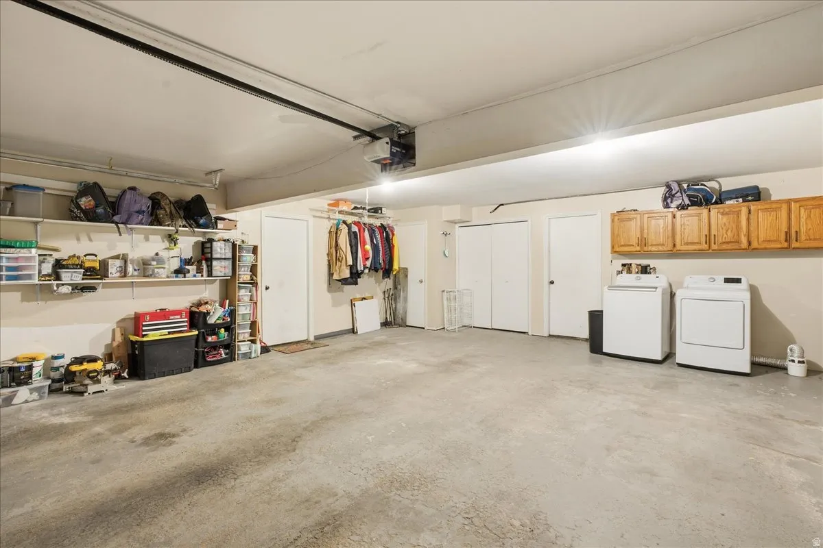 Concrete flooring, built-in wall shelving, light wood cabinetry, and a clothes hanging rack