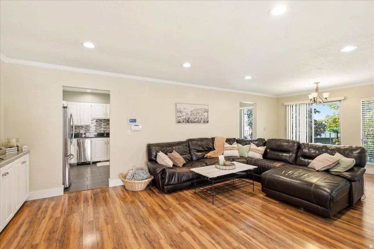 Spacious living area featuring wood-finish flooring and crown molding