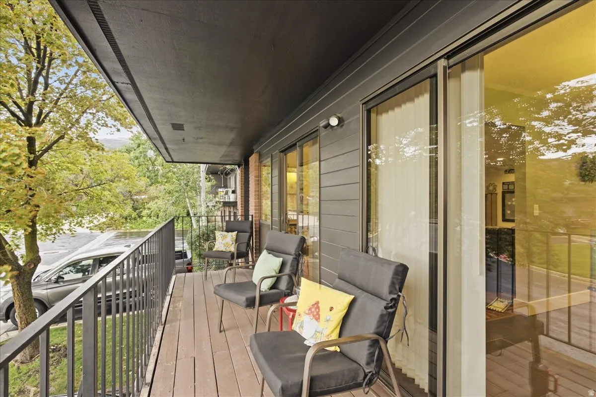 Outdoor balcony with dark wood-finish flooring and a black metal railing