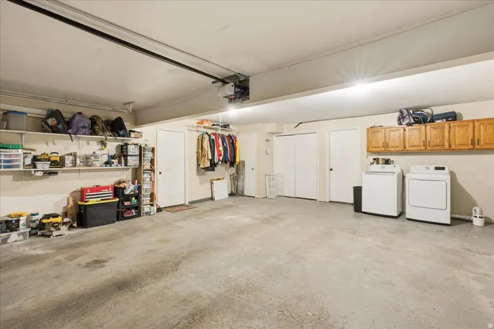 Concrete flooring, built-in wall shelving, light wood cabinetry, and a clothes hanging rack