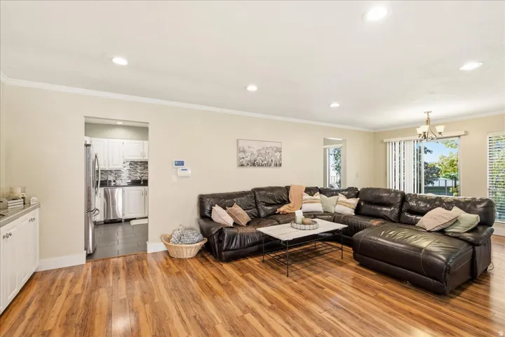 Spacious living area featuring wood-finish flooring and crown molding